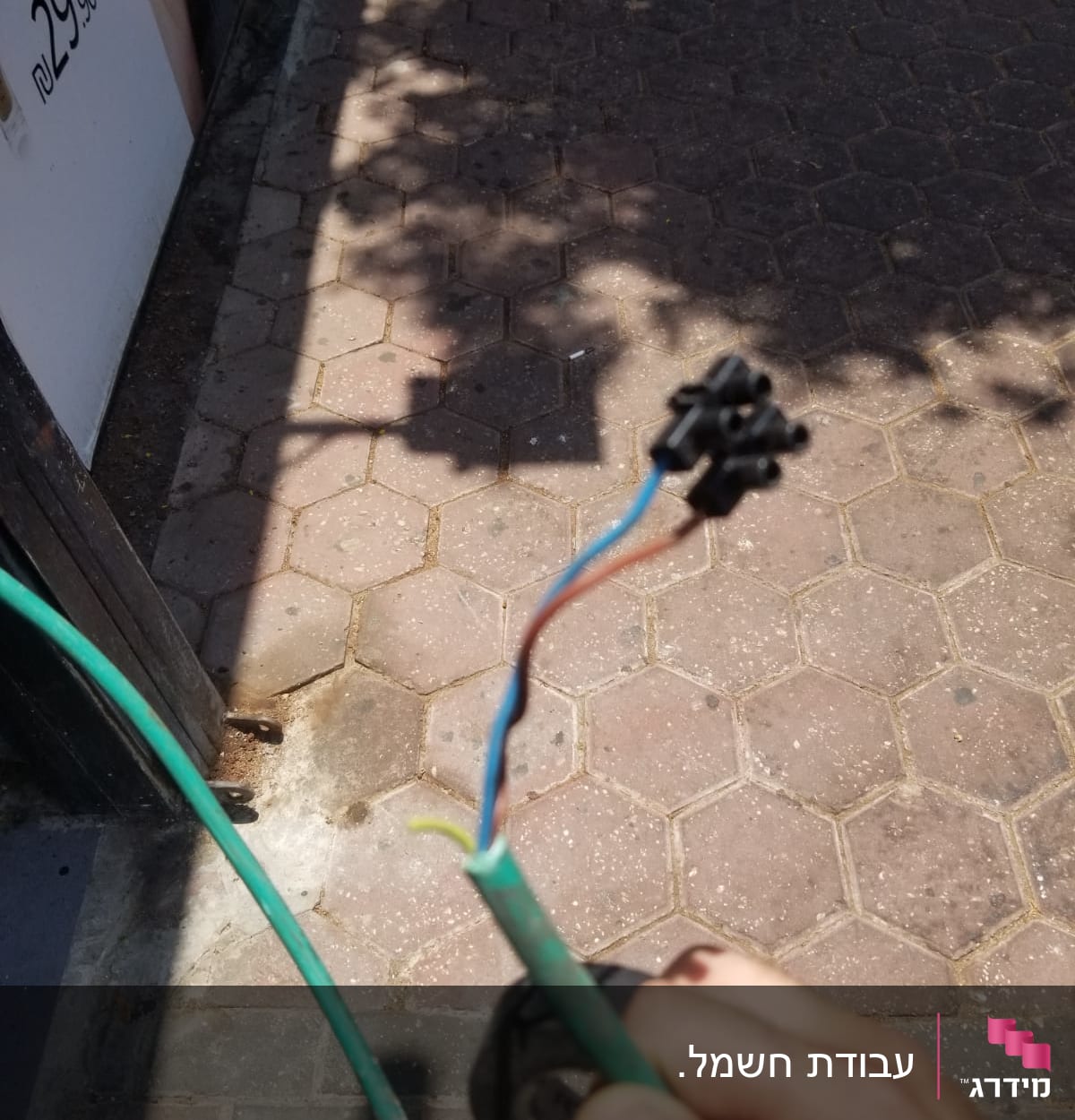 חוטי חשמל חשופים ביד של חשמלאי